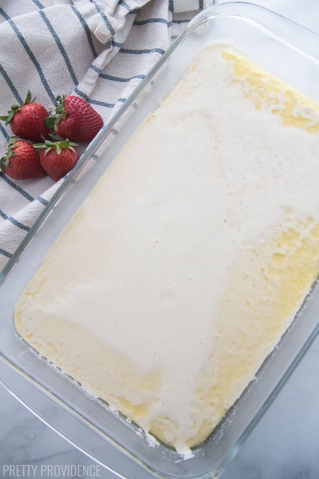 German Pancake batter with melted butter in a 9x13 glass baking dish.
