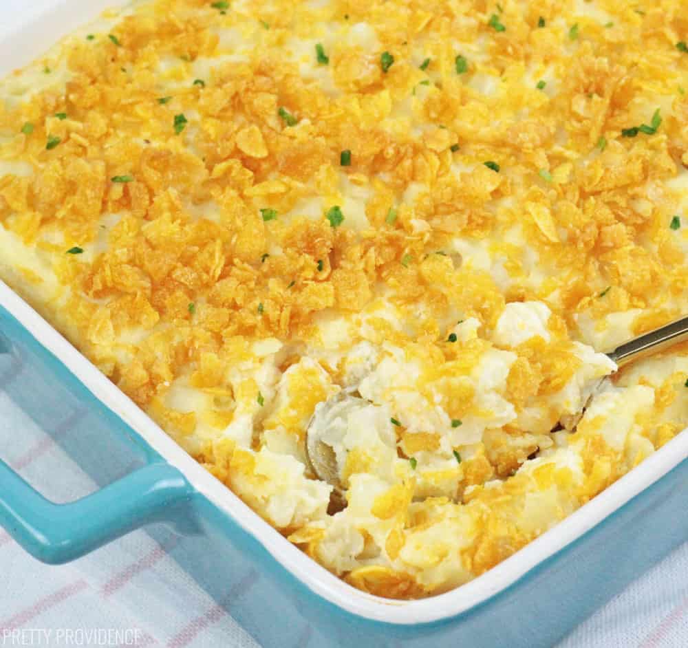 Cheesy Potato Casserole recipe AKA funeral potatoes in a blue baking dish and spoon.