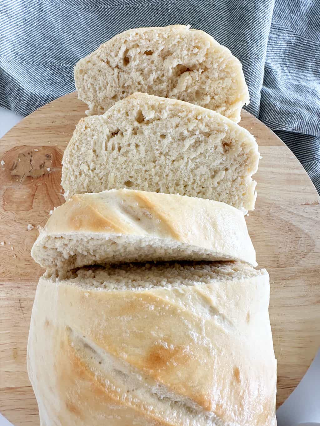Birds eye view of a loaf of rustic French bread with one end cut into slices.